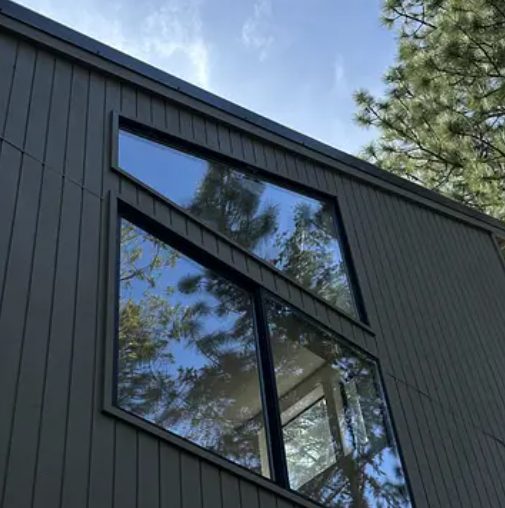 Spotless windows on a modern home reflecting the trees