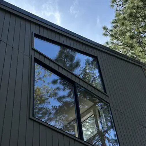 Spotless windows on a modern home reflecting the trees