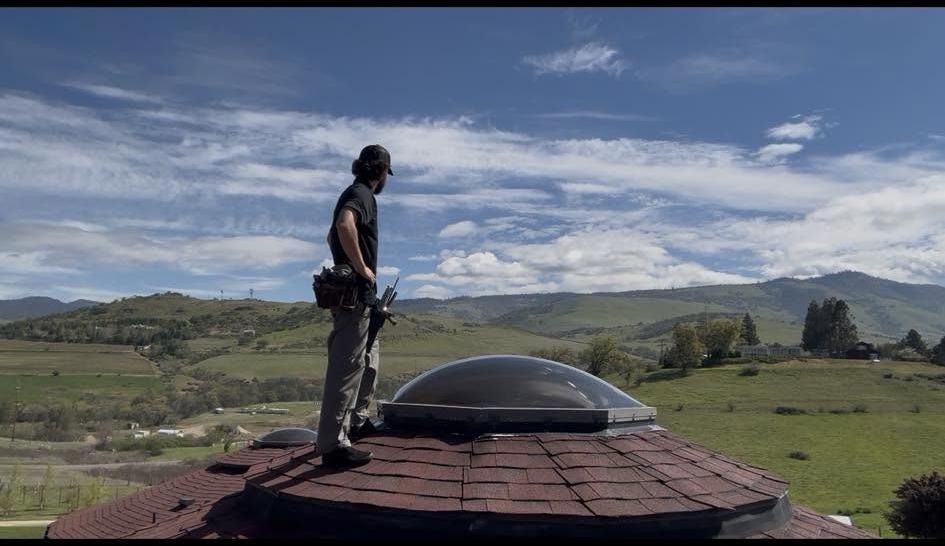A Valley Boys technician on a rooftop overlooking the Willamette Valley