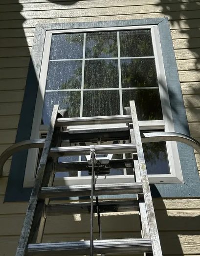 A window mid-clean with streaked, soapy glass