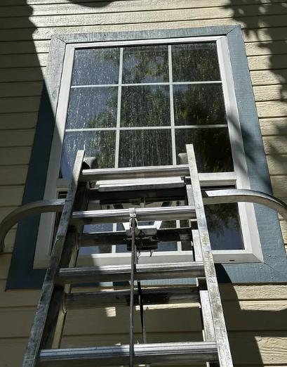 A window mid-clean with streaked, soapy glass